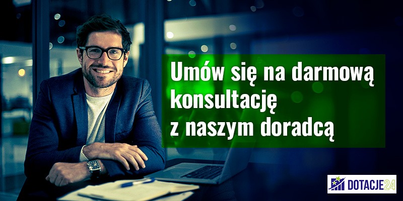 Uśmiechnięty mężczyzna w okularach i marynarce siedzi przy biurku z laptopem, notatnikiem i długopisem. Na ekranie widoczny napis: Umów się na darmową konsultację z naszym doradcą.