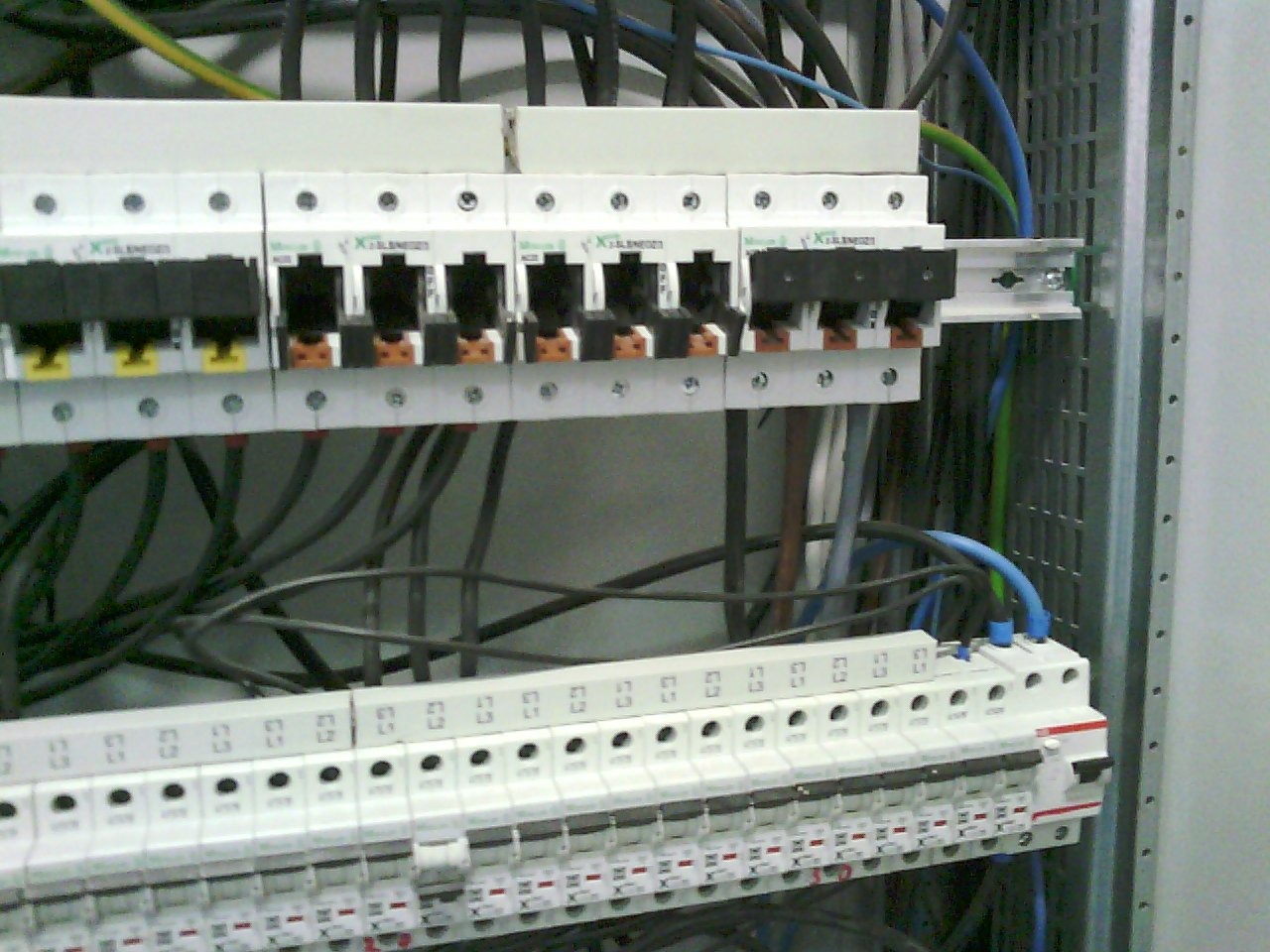 Szczegółowe ujęcie szafy elektrycznej z zainstalowanymi bezpiecznikami i okablowaniem, widoczna metalowa konstrukcja szafy.