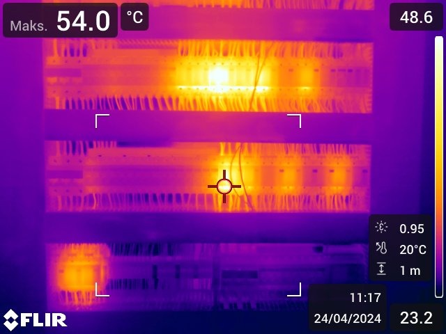 Termogram rozdzielnicy elektrycznej z widocznymi punktami o podwyższonej temperaturze, zarejestrowany urządzeniem FLIR.