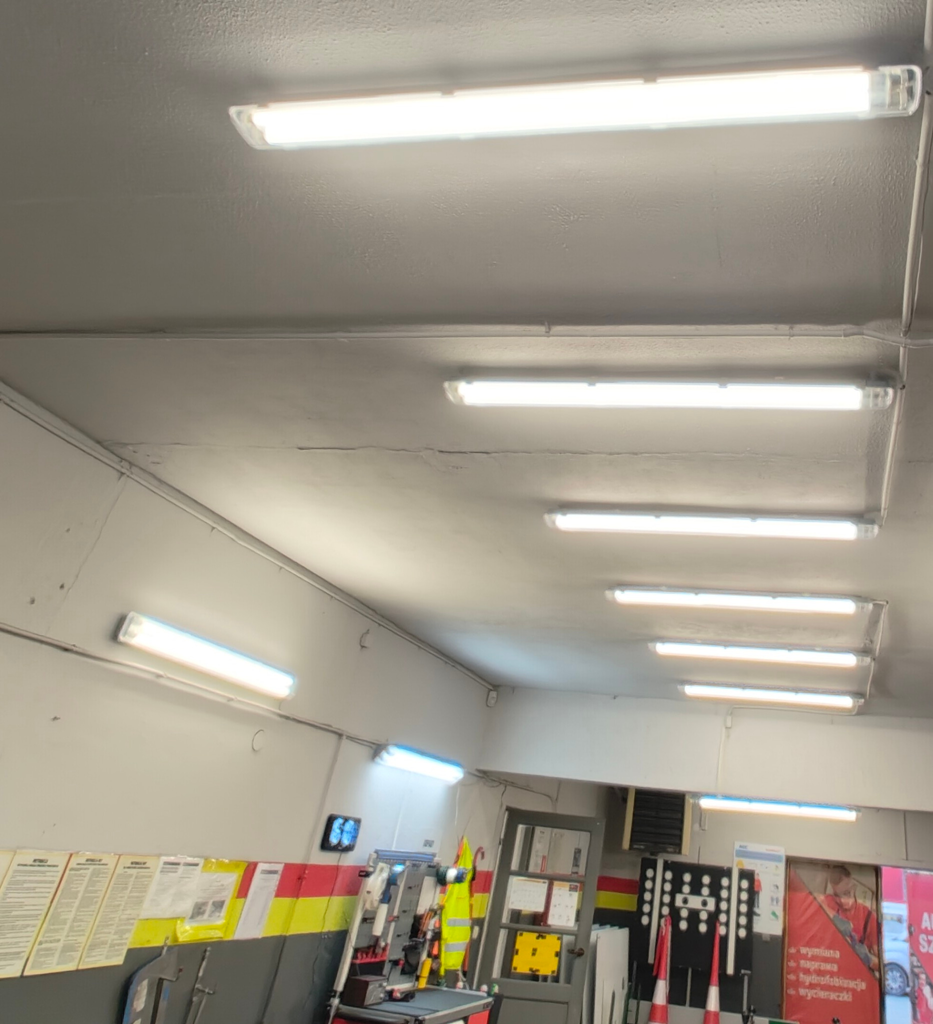 Montaż oświetlenia w serwisie samochodowym.