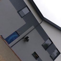 Usługi Malarsko-Budowlane - Szara elewacja budynku z oknami, częściowo zabezpieczonymi folią, widoczny sprzęt budowlany na ścianie oraz fragment dachu z rynną.