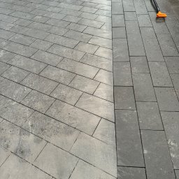 MIKOLO LOGISTIC SPÓŁKA Z OGRANICZONĄ ODPOWIEDZIALNOŚCIĄ - Ułożona część nawierzchni z szarej kostki brukowej w dwóch odcieniach, widoczna żółta mata ochronna i łopata z ziemią.