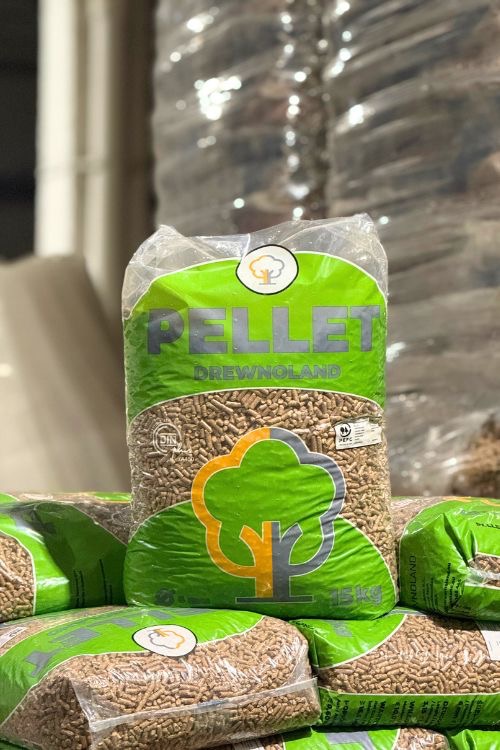 Worki z pelletem drzewnym DrewNoland 15kg, ułożone jeden na drugim. Pellet od producenta z Pustyni, gotowy do transportu i użycia jako ekologiczne paliwo.