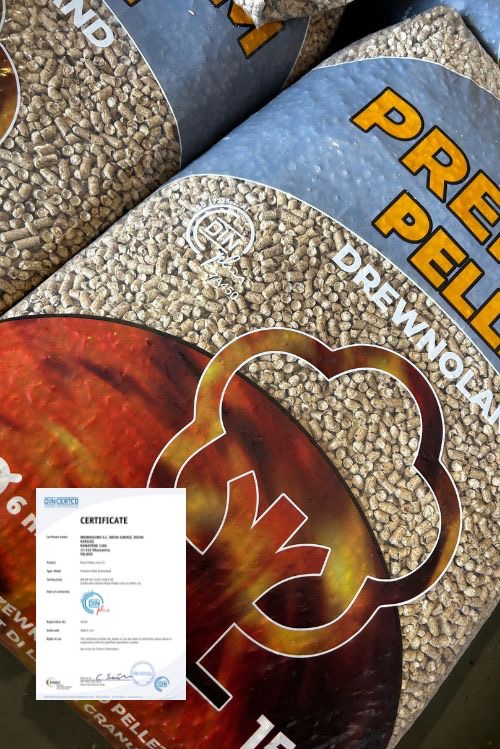 Worki z pelletem drzewnym z certyfikatem jakości DINplus. Torby z nadrukiem płomieni na jasnoniebieskim tle, wypełnione drobnymi granulkami. Certyfikat DIN na pierwszym planie.