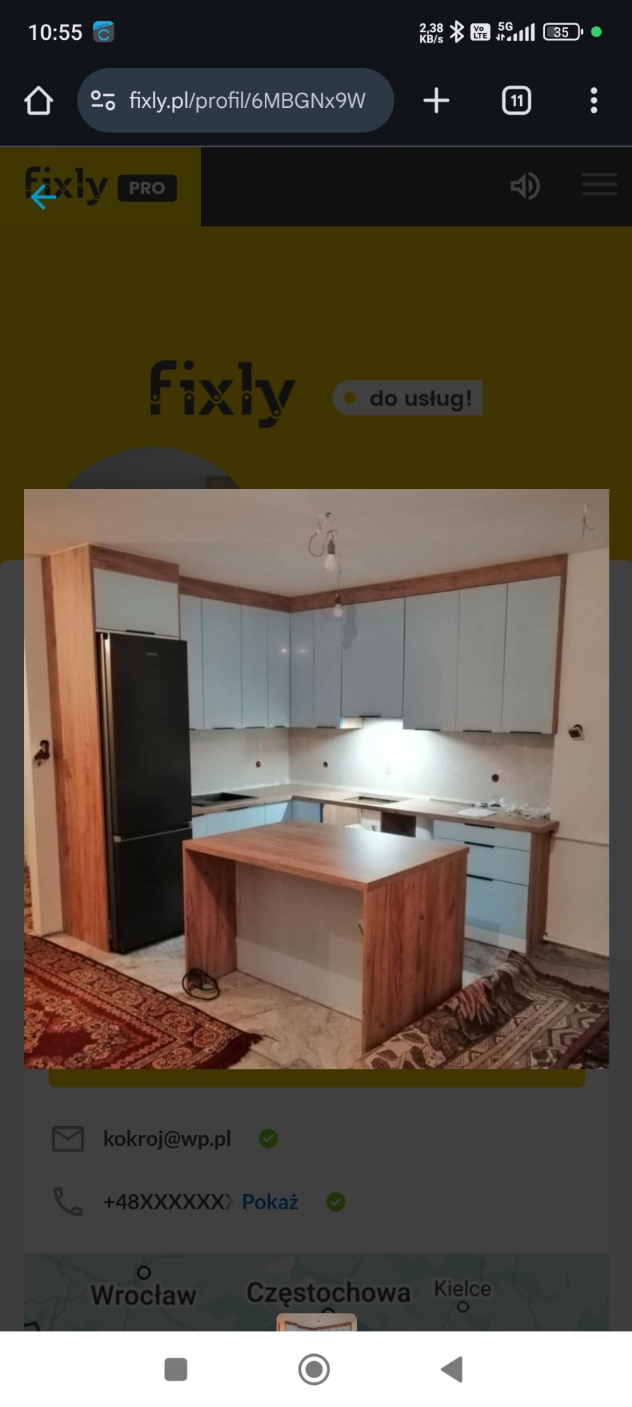 Jasna kuchnia z drewnianym blatem i wyspą, widoczna na zdjęciu z perspektywy podłogi, z dywanem w orientalne wzory. Uwagę zwraca nowoczesny design i oświetlenie.