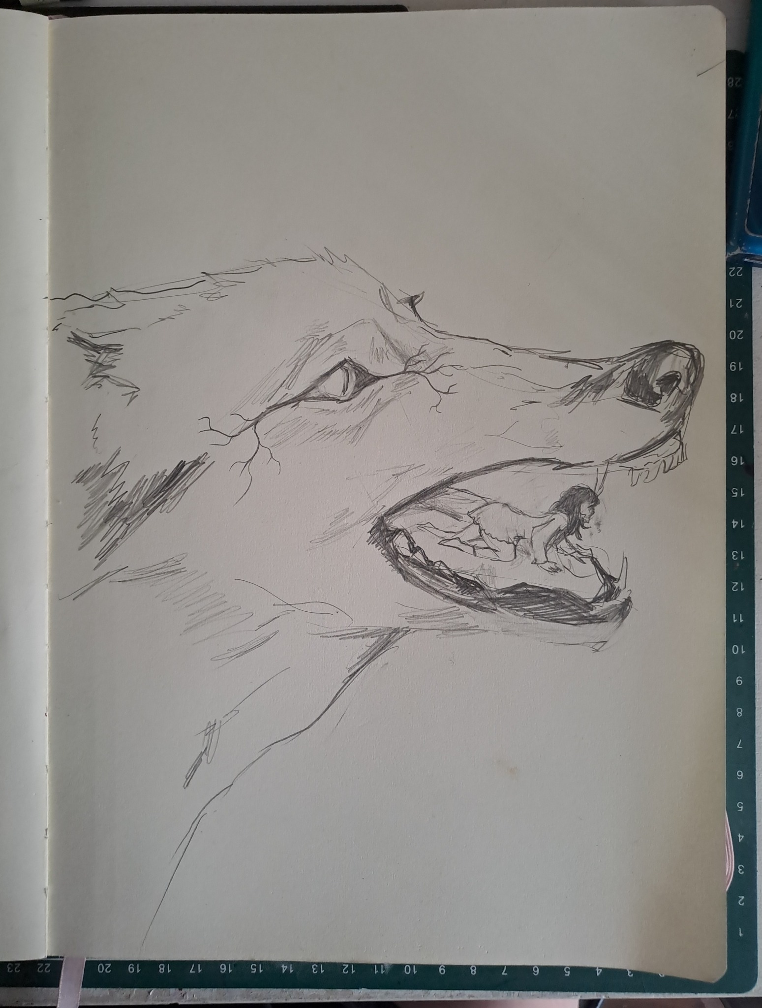 Szkic ołówkiem przedstawiający głowę wilka z otwartą paszczą, w której widać skuloną postać kobiety, wykonany w notesie z podziałką.