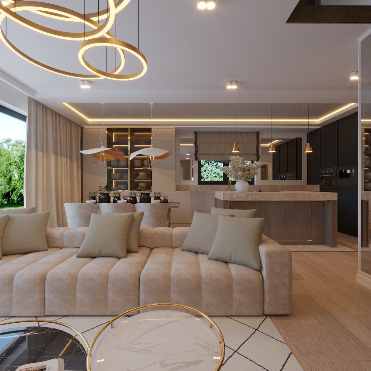 Jasny salon z beżową sofą modułową, okrągłymi stolikami kawowymi z marmurowymi blatami i złotymi obwódkami, oraz otwartą kuchnią z wyspą i czarnymi szafkami w tle.