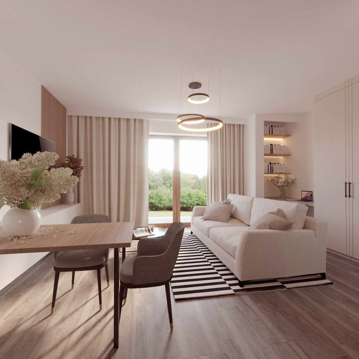 Jasne wnętrze salonu z jadalnią: drewniany stół z wazonem kwiatów, szare krzesła, biała sofa na czarno-białym dywanie, okrągłe lampy wiszące, zabudowana półka z książkami, widok na ogród przez okno.