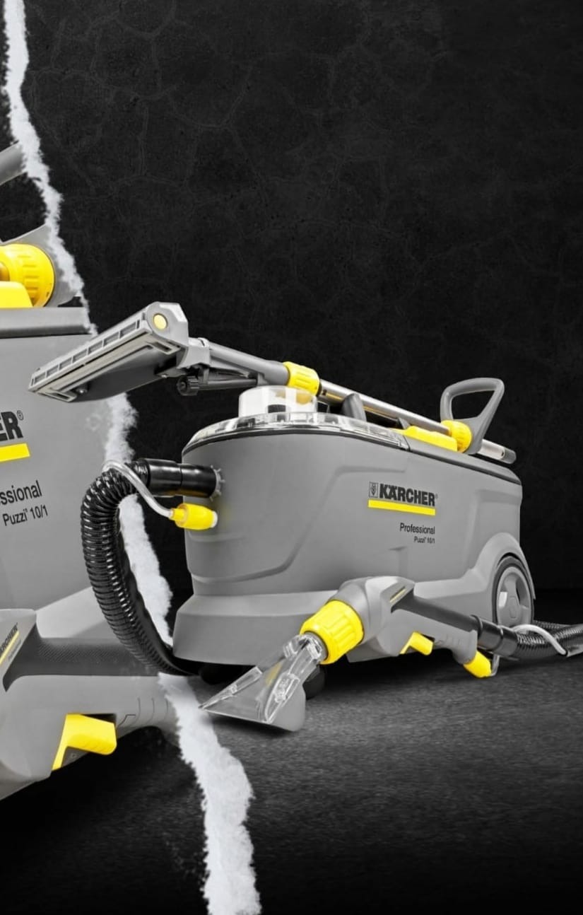 Profesjonalny odkurzacz piorący Kärcher Puzzi 10/1 i Puzzi 16/1 w trakcie czyszczenia ciemnego dywanu, widoczny efekt działania urządzenia.