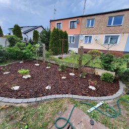 Ułożona kostka razem z włókniną nasadzenie kwiatów oraz drzewek rozsypanie kory . Według życzenia klijętki . 