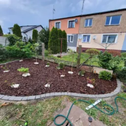 Ułożona kostka razem z włókniną nasadzenie kwiatów oraz drzewek rozsypanie kory . Według życzenia klijętki .