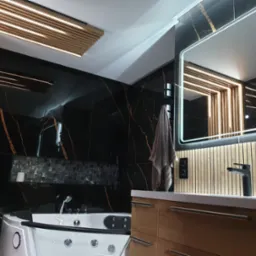 Elegancka łazienka z czarnymi płytkami z motywem marmuru, podświetlanym sufitem z drewnianymi listwami, wanną z hydromasażem i szafką z umywalką z drewnianymi lamelami.