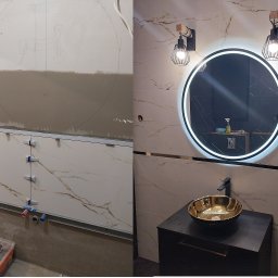 Usługi Remontowe, Wykończenie Wnętrz Artur Kowalski - Łazienka w trakcie wykończenia: widok przed i po ułożeniu płytek marmurowych, zarys instalacji na ścianie, narzędzia do układania płytek oraz gotowa umywalka ze złotą misą i podświetlanym lustrem.