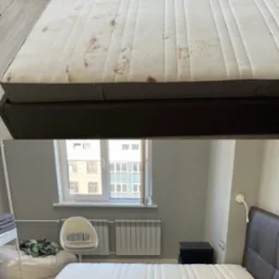 Porównanie materaca przed i po czyszczeniu, widoczne uporczywe plamy usunięte na białym poszyciu, w tle jasne wnętrze pokoju z grzejnikiem i oknem.