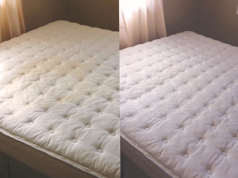 Widok z góry na materac z widoczną różnicą w czystości: po lewej stronie widoczne plamy i zabrudzenia, po prawej materac czysty, po zabiegu czyszczenia.