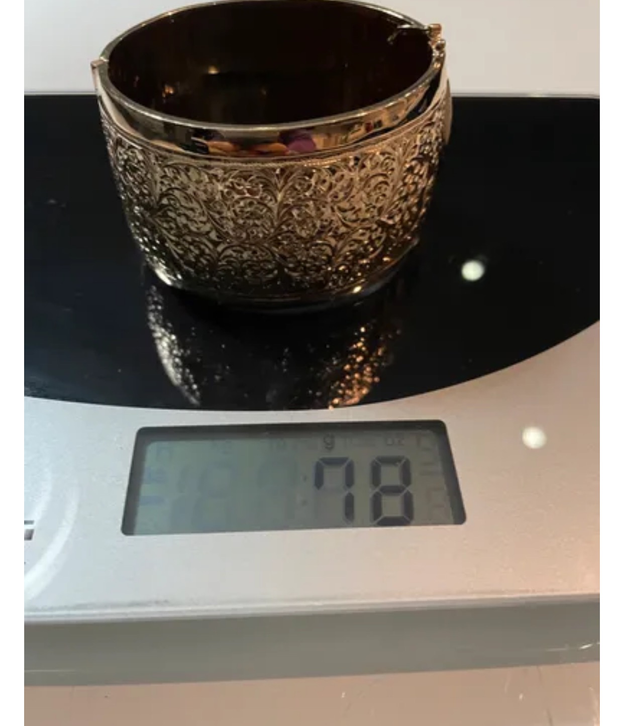 Dwa złote, zdobione bransoletki na wadze elektronicznej wskazującej 78 gram.