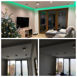 Bartłomiej Kundt - Sufit podwieszany z oświetleniem LED i punktami świetlnymi w salonie z choinką, widok na ułożoną podłogę w jodełkę, ściany po położeniu gładzi i malowaniu, widoczne okno balkonowe.