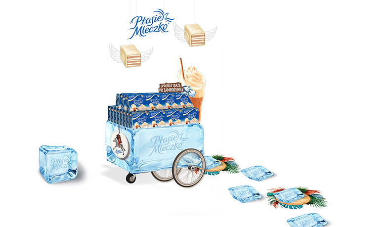 Promocyjna ekspozycja słodyczy Ptasie Mleczko w wózku imitującym lód, z elementami dekoracyjnymi i hasłem zachęcającym do spróbowania po zamrożeniu.