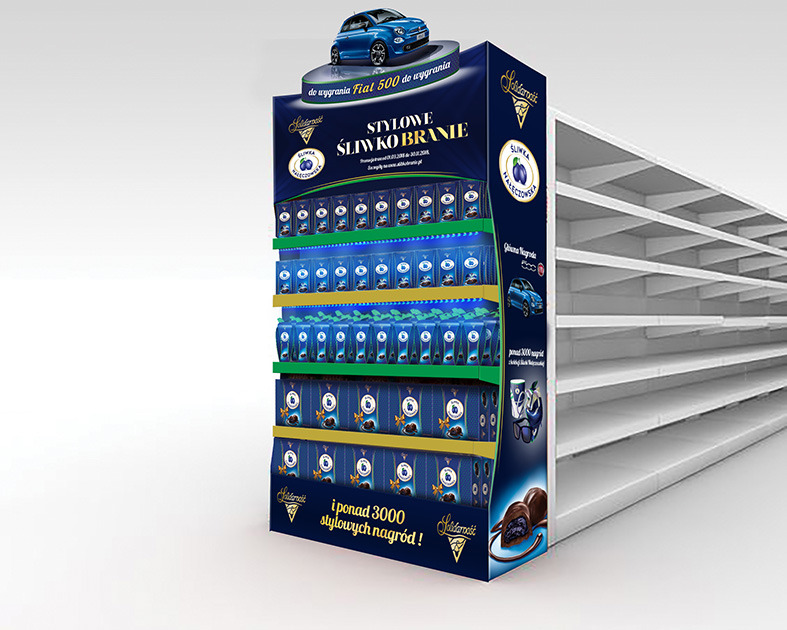 Ekspozytor reklamowy marki Solidarność z produktami Śliwka Nałęczowska, z miniaturą samochodu Fiat 500 na górze, umieszczony na tle pustych półek sklepowych.