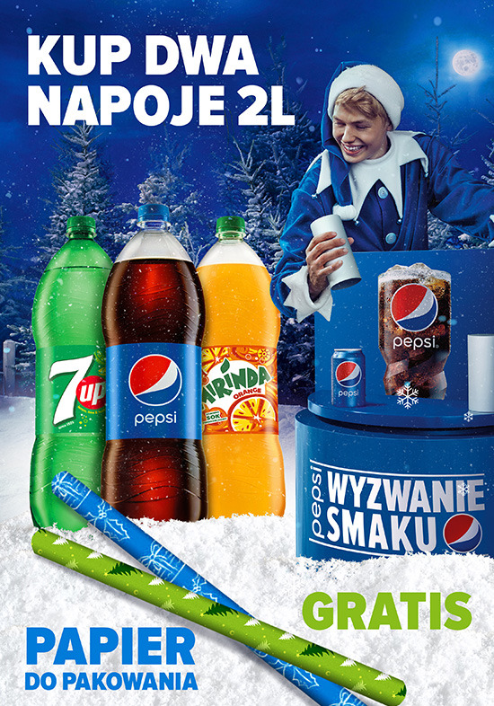 Promocja napojów gazowanych 2L (7up, Pepsi, Mirinda) z darmowym papierem do pakowania, prezentowana na tle zimowej scenerii z choinkami i postacią w kostiumie.