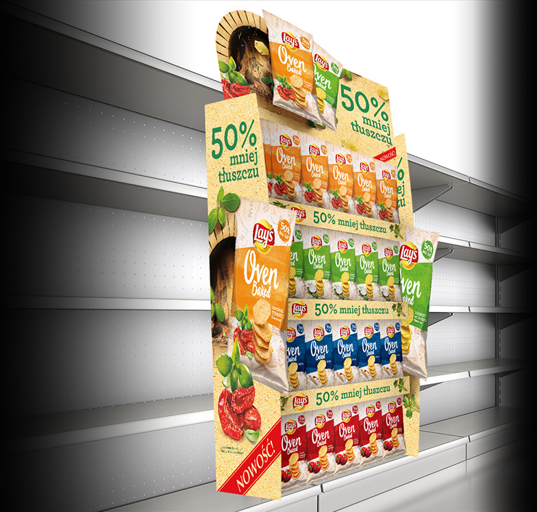 Ekspozytor reklamowy z różnymi smakami chipsów Lay's Oven Baked, z hasłem '50% mniej tłuszczu', ustawiony na pustych półkach sklepowych, z akcentami w postaci wizualizacji pieca i świeżych składników.