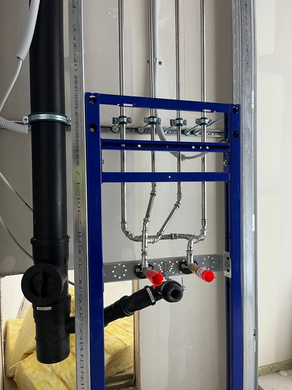 Stal nierdzewna i Geberit: instalacja wod-kan do umywalki z obiegiem wody. Widoczne rury, mocowania, stelaż podtynkowy i izolacja. Precyzyjne wykonanie.