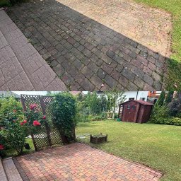 OXO Expert - Porównanie stanu kostki brukowej przed i po czyszczeniu, widok na taras z kostki brukowej, po lewej stronie schody, w tle ogród z domkiem narzędziowym i trejaż z różami.
