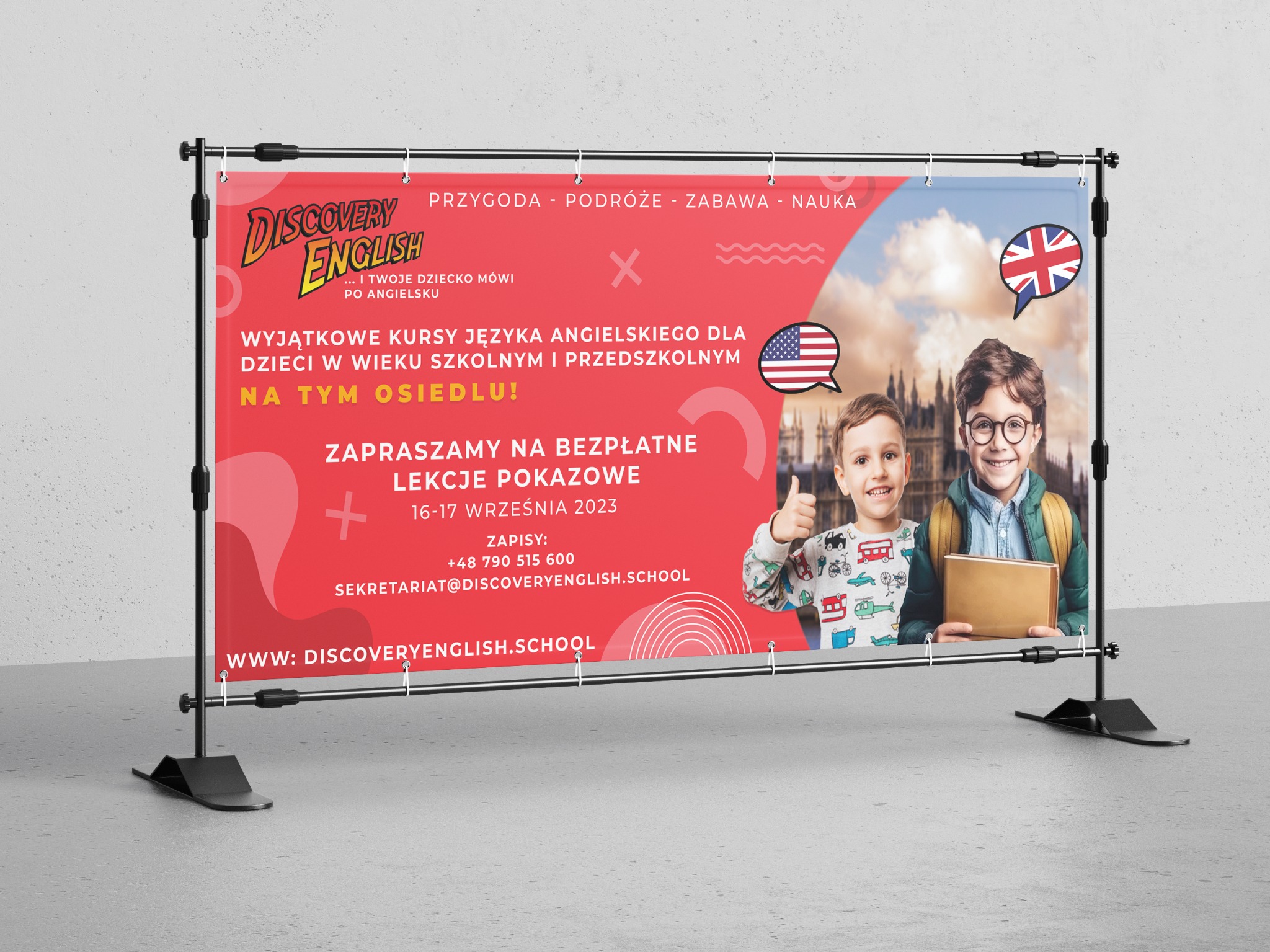 Baner reklamowy szkoły językowej Discovery English z uśmiechniętymi dziećmi, flagami USA i Wielkiej Brytanii, informacją o bezpłatnych lekcjach pokazowych i adresem strony internetowej, umieszczony...