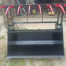 TOM-STAL TOMASZ KŁAKULAK - Czarny, metalowy kosz z czerwonymi uchwytami, prawdopodobnie do traktora, wykonany na zamówienie. Widoczne ślady spawania i świeża farba.