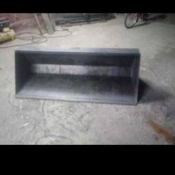 TOM-STAL TOMASZ KŁAKULAK - Metalowa skrzynia o prostokątnym kształcie, wykonana z blachy, widoczna na betonowej posadzce w warsztacie. W tle narzędzia i rower.