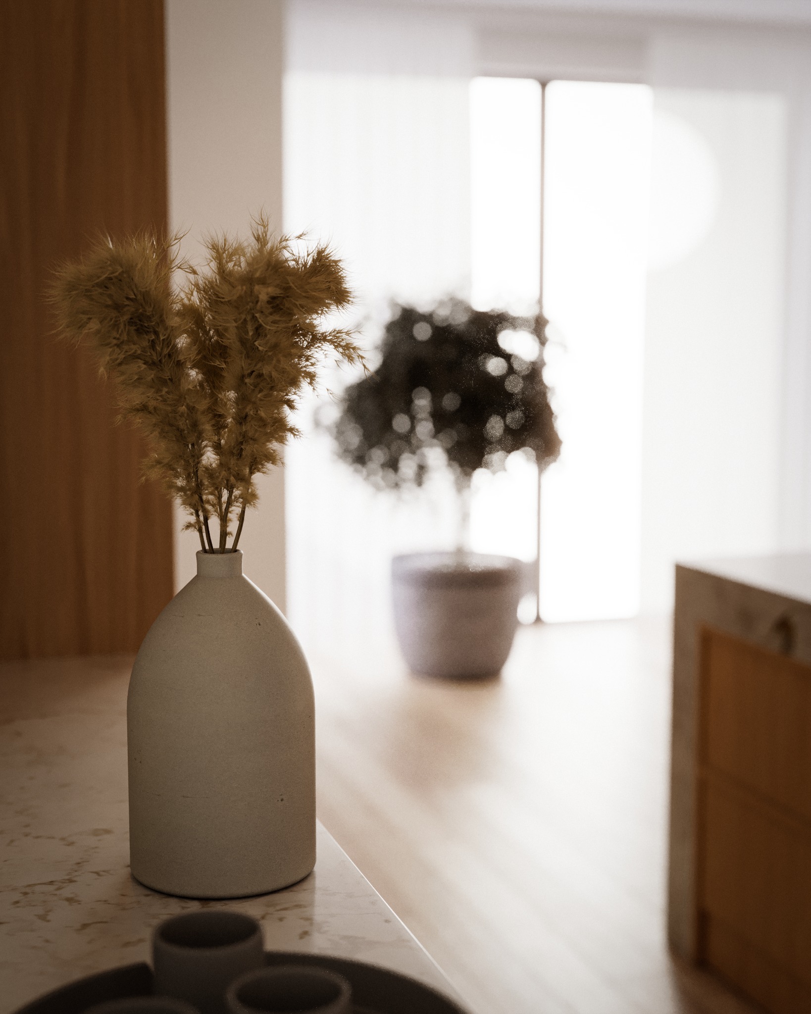 Minimalistyczne wnętrze: wazon z suszonymi trawami na marmurowym blacie, w tle rozmyta roślina doniczkowa i jasne okno.