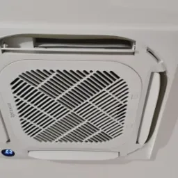 Biała, sufitowa jednostka klimatyzacyjna Rotenso z widocznym wyświetlaczem temperatury 23 stopnie Celsjusza.