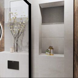 Joanna Marciniak - Nowoczesna łazienka z owalnym lustrem z podświetleniem LED, umywalką nablatową na czarnej szafce, szklaną kabiną prysznicową i wnęką z półkami na kosmetyki.