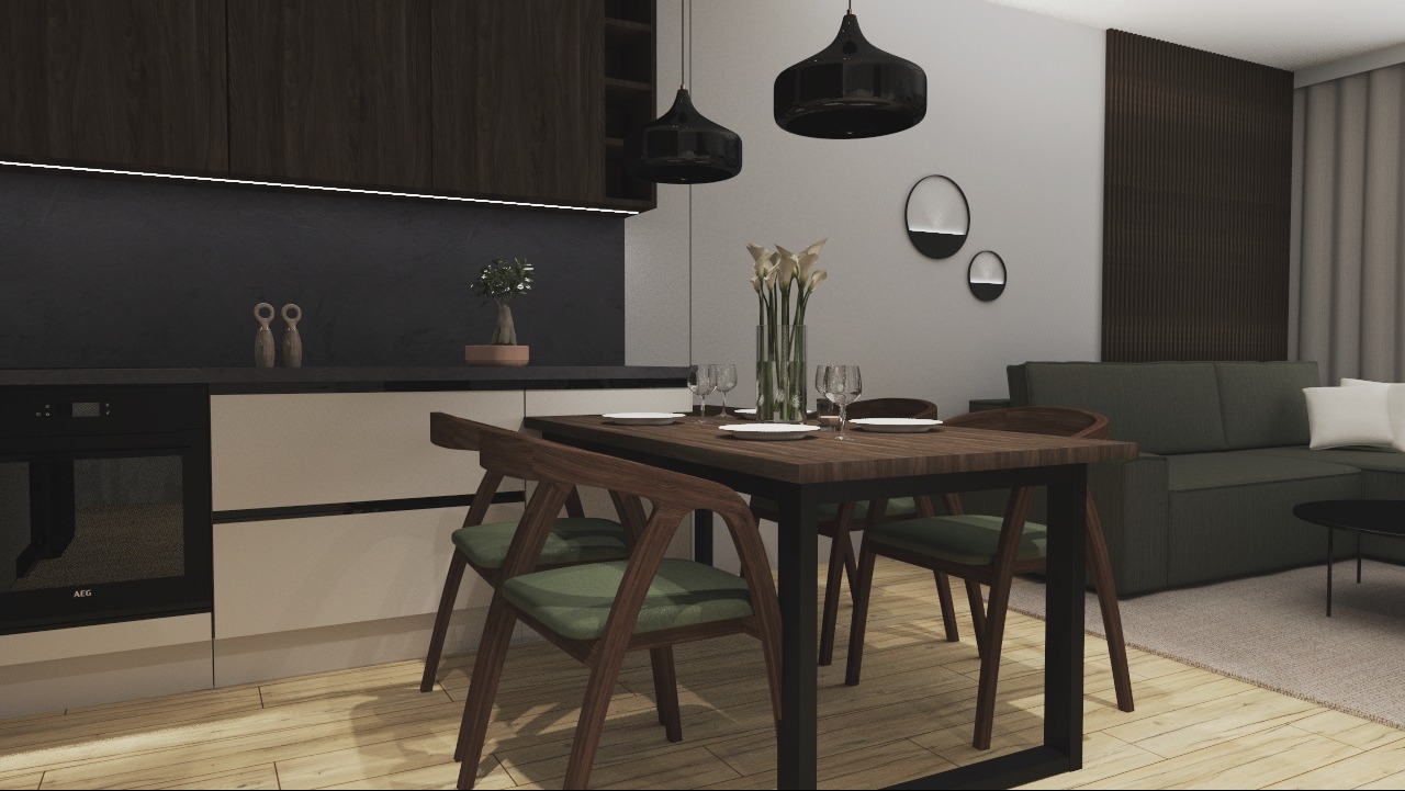 Nowoczesna kuchnia z ciemnymi szafkami górnymi, jasnymi dolnymi, drewnianym stołem z krzesłami z zielonymi siedziskami, czarnymi lampami wiszącymi i salonem w tle.