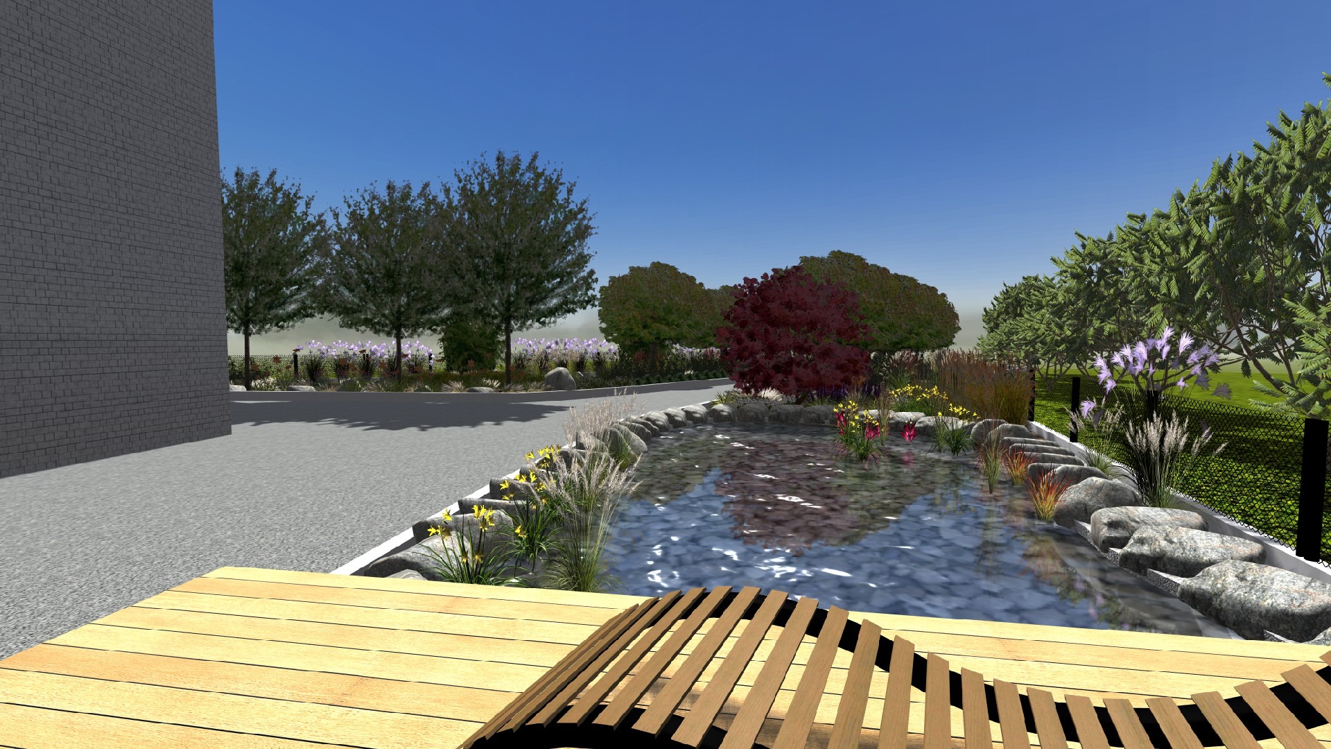 Wizualizacja projektu ogrodu z oczkiem wodnym otoczonym kamieniami, ozdobnymi trawami i kwiatami, widok z drewnianego tarasu, w tle budynek i drzewa.