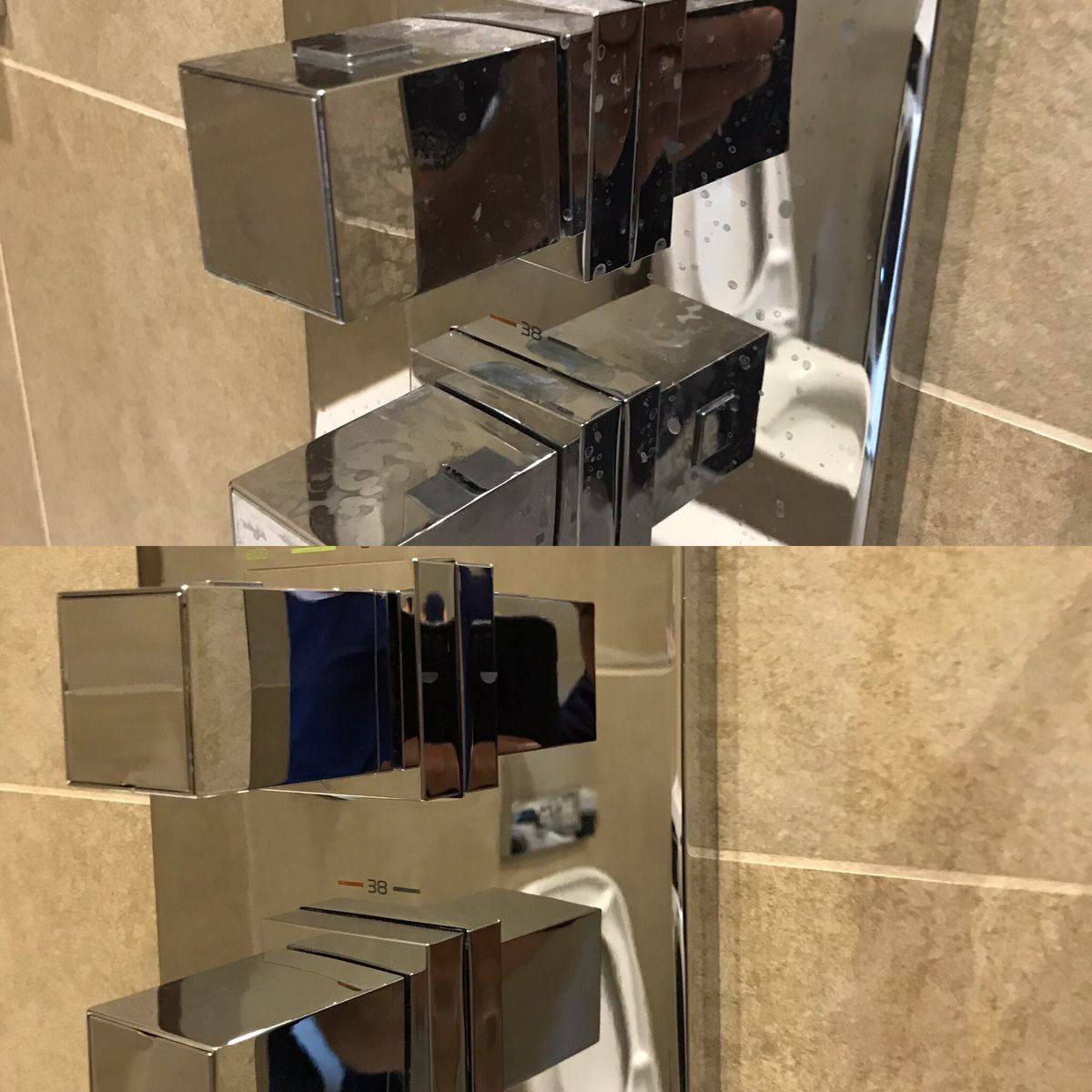 Bateria prysznicowa z kwadratowymi pokrętłami, widoczne ślady po wodzie na chromowanej powierzchni, płytki ceramiczne w tle.