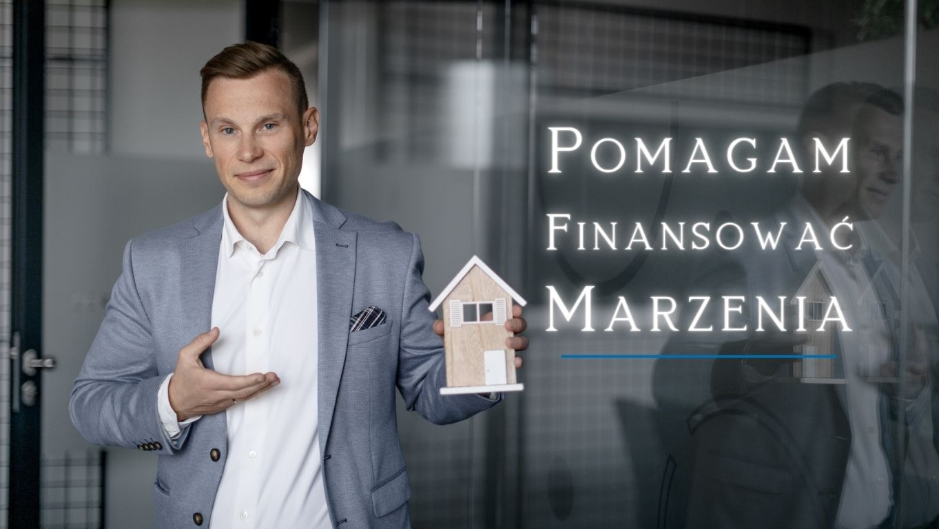 Mężczyzna w szarej marynarce prezentuje model domu, obok napis 'Pomagam Finansować Marzenia' na szklanej powierzchni.