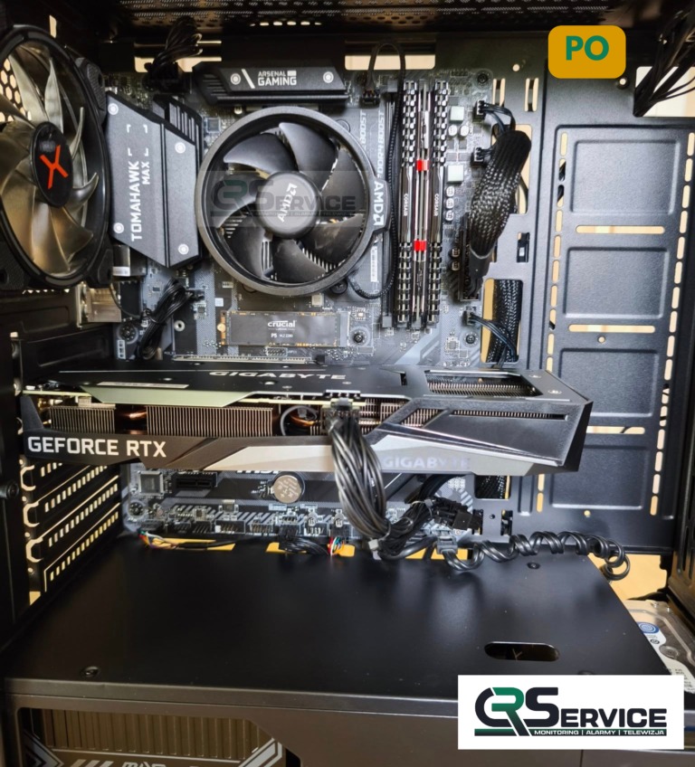 Wnętrze obudowy komputera stacjonarnego z kartą graficzną GeForce RTX i płytą główną Gigabyte. Widoczne chłodzenie procesora AMD i pamięć RAM Corsair.