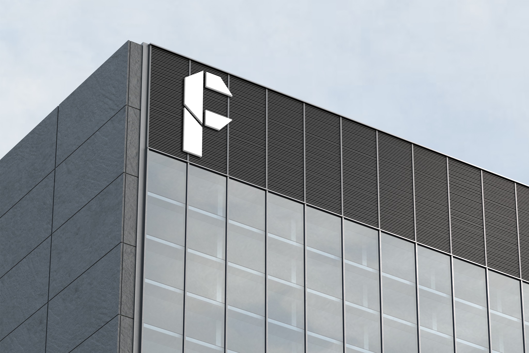 Białe, geometryczne logo firmy umieszczone na rogu nowoczesnego biurowca z szarą elewacją i szklanymi oknami, widok z dołu na błękitne niebo.