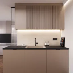 Nowoczesna kuchnia w odcieniach beżu i brązu z drewnianą podłogą w jodełkę, czarnym blatem, minimalistyczną armaturą i oświetleniem punktowym, z książką kucharską opartą o ścianę.