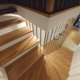 Nowoczesne schody z drewnianymi stopniami i metalową balustradą, widok z góry, jasne oświetlenie.