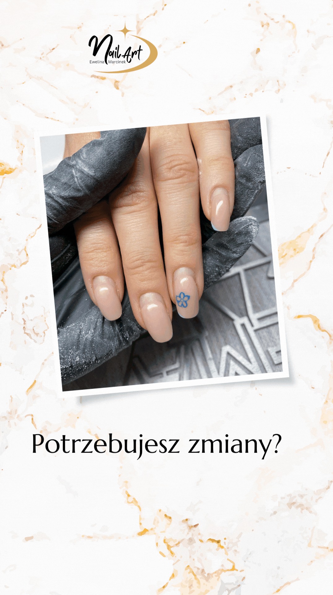 Dłoń z beżowym manicure i niebieskim kwiatowym wzorem na jednym paznokciu, trzymana przez dłoń w czarnej rękawiczce na szarym tle.