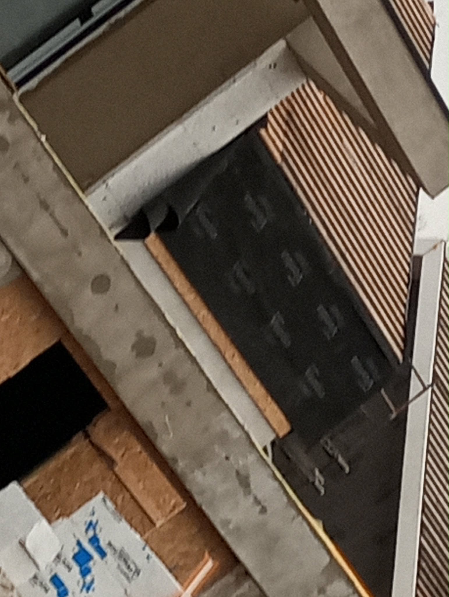 Fragment dachu w trakcie budowy: widoczne warstwy izolacji, membrany i elementy konstrukcyjne. Ujęcie z bliska, ukazujące detale materiałów.