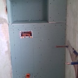 TOMMY-BUD - Konstrukcja z płyty karton-gips z wnęką i instalacją hydrauliczną oraz elektryczną w trakcie montażu w łazience.