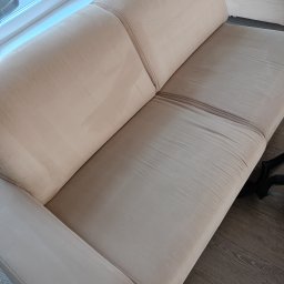 SLY master - Beżowa kanapa z widoczną różnicą w odcieniu po czyszczeniu, fragment węża odkurzacza w prawym dolnym rogu.