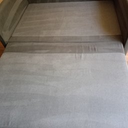 SLY master - Sofa w rozłożonej formie z widocznymi śladami czyszczenia na tapicerce, ukazującymi różnicę w odcieniach szarości.