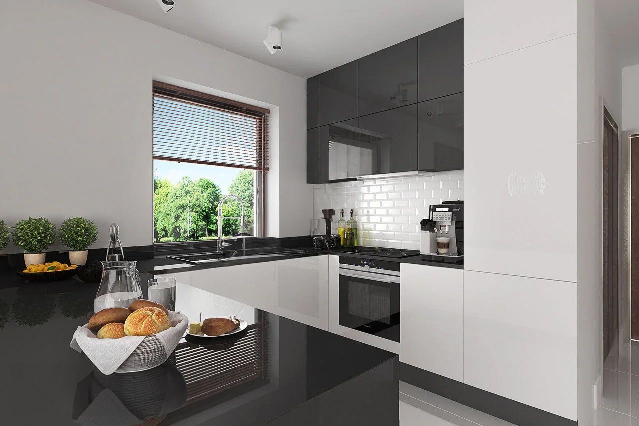 Nowoczesna kuchnia w Jaktorowie z czarno-białymi szafkami na wysoki połysk, blatem z czarnego kamienia i oknem z widokiem na zieleń, na blacie koszyk z pieczywem i dzbanek z wodą.