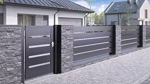 Nowoczesna brama przesuwna w kolorze antracytowym z poziomymi, srebrnymi akcentami, osadzona na słupkach wykończonych kamieniem dekoracyjnym, na tle domu z garażem i chodnika z kostki.