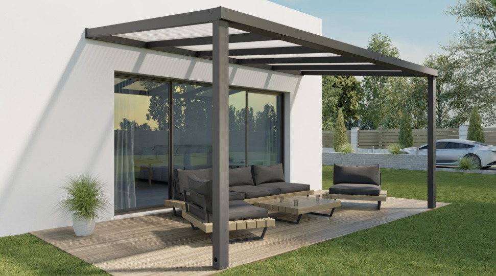 Nowoczesna, szara konstrukcja z zadaszeniem na tarasie przylegającym do białego budynku, z drewnianym podestem i meblami wypoczynkowymi w odcieniach szarości, widok na ogród z zaparkowanym samochodem.