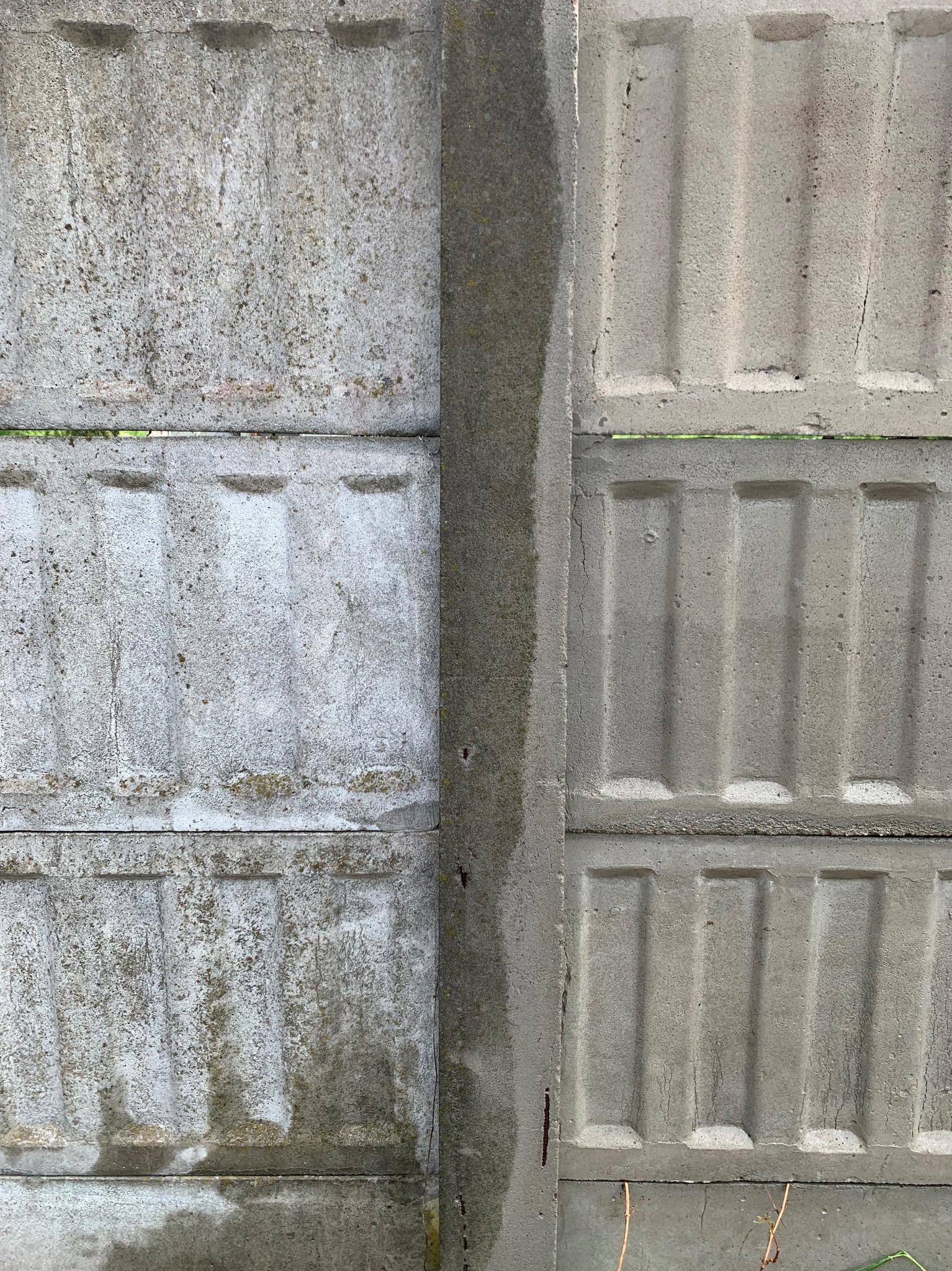 Fragment betonowego ogrodzenia: Po lewej stronie widoczny brud i ślady wilgoci, po prawej czysta powierzchnia z delikatnym wzorem.